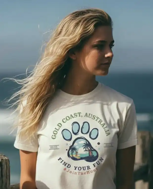Woman wearing a white Golden Paw signature series 200gsm tee at the Surfers Paradise beach, representing the local surf lifestyle.